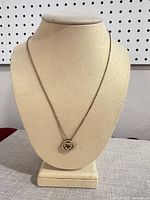Necklace on display bust showing full view of chain and pendant