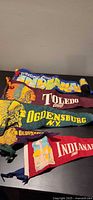 Stack of five felt pennants showing titles and colours