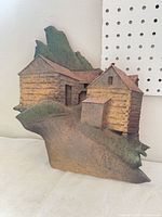 Front view of ceramic relief showing full scene of barns and hillside