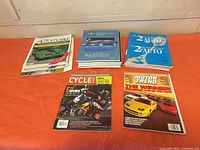 Overview of three stacks of magazines on orange surface