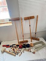 Full set showing four mallets, balls, wickets, scoring pegs and stake mallet on table