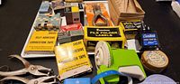 Overview of entire assortment showing punch, label embosser, ink, labels, correction tape, staple remover, tin, staples, eyelet packets