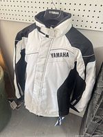 Front view of white and black Yamaha women’s snowmobile jacket on hanger