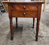 front view of end table showing two drawers and turned legs