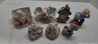 All seven porcelain figurines and planters grouped