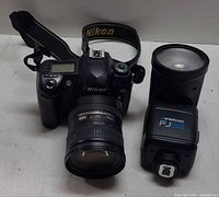 Front view of Nikon DSLR with VR zoom lens and Westcott FJ80 flash