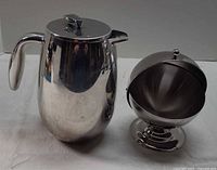 Carafe and covered sugar bowl side by side