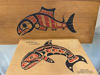 Front of both cedar boxes showing salmon graphics