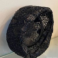 Side angle of the black straw beanie hat showing woven texture and interior mesh