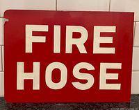 Front view of red metal sign with white FIRE HOSE text
