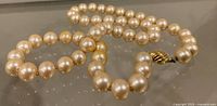 Necklace laid out showing faux pearls and clasp