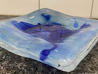 Oblique view showing blue fused glass dish signed corner