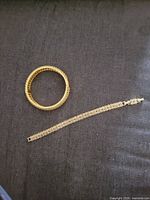 Top view showing both bracelets on dark fabric background