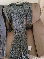 Front view of heathered charcoal long-sleeve knit bodycon dress on sofa