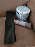 All three items grouped on couch: lunch box, oven liner, shelf liner roll