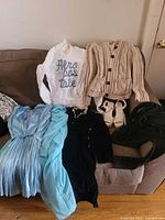 Overview of clothing items and sandals on sofa