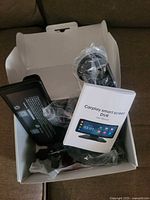 Open box showing touchscreen DVR, mount, manual and cables