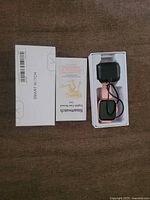 watch in tray with charger attached, manual and box visible