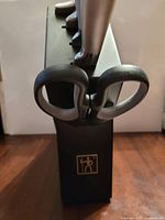 Front view of black Henckels knife block with kitchen shears inserted