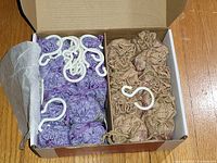 Open box showing 10 purple lavender sachets, 10 tan cedar sachets, and white hooks