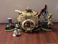 Front view of assembled Yoda's Hut with minifigures positioned and accessories