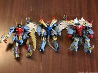 All three custom painted Dinobot figures standing on tabletop