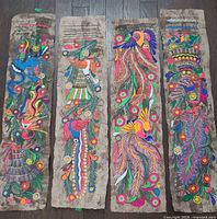 All four painted birch bark panels laid out side by side on floor