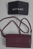 Front view of burgundy Matt & Nat clutch with dust cover