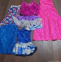 All six dance costumes arranged on floor