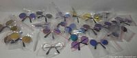 All 22 pairs of pet sunglasses in clear bags on white background