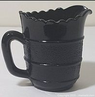Side view showing creamer profile, handle, spout, textured bands