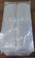 Front of sealed package showing MR&HM branding and folded silver satin sheet