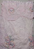 Full view of folded lace curtain panel showing attached valance and floral lace pattern