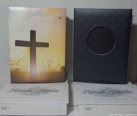 Front covers of both guest books showing cross design and black quilt design