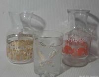 Three glassware pieces: frosted ice bucket front, two clear carafes behind