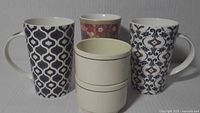 Front view of all five mugs showing patterns and sizes