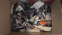 Open box showing large quantity of assorted new makeup products