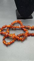 Full view of extra long Baltic amber nugget necklace coiled