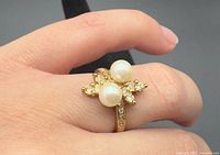 Ring on hand showing twin pearls and rhinestone leaf design