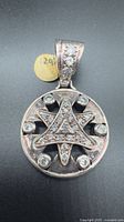 Front view showing circular pendant with hexagram and cubic zirconia stones