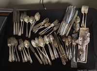 Overview of all flatware pieces laid out on black surface