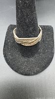 Front view of sterling silver braided ring on display stand