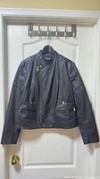 Front view of black leather moto jacket on hanger