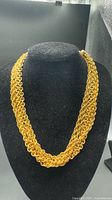 Full view of six-strand gold-tone Monet necklace on display bust