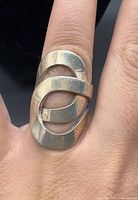 Front view of sterling silver abstract loop ring on finger
