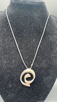 Full view of sterling silver swirl pendant on black cord displayed on bust