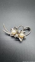 Front view of sterling silver brooch showing twin flower design with pearls