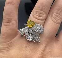 Ring on hand showing heart citrine, bow of pavé stones, marquise cluster