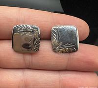 Front view showing engraved leaf pattern on both cufflinks