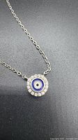 Front view of round evil eye pendant on chain
